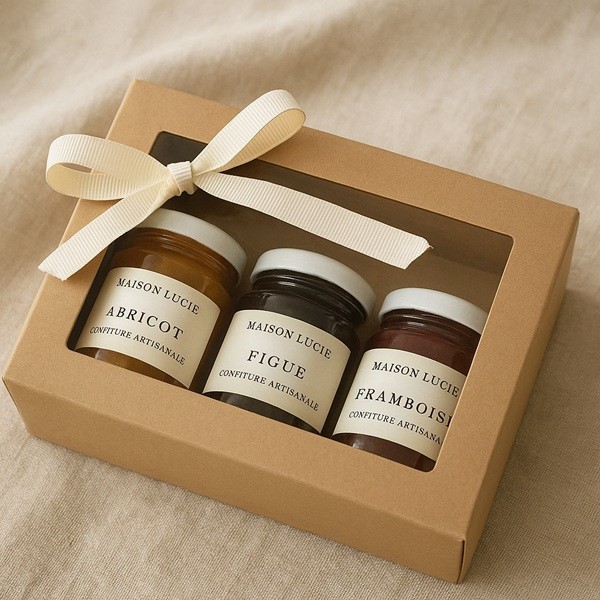 Coffret cadeau gourmand Maison Lucie avec trois mini pots de confiture artisanale aux parfums abricot, figue et framboise, présenté dans une élégante boîte en kraft avec ruban.