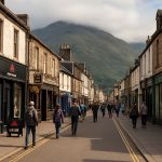 Fort William town centre High Street en Écosse avec boutiques outdoor, pubs traditionnels et montagnes des Highlands en arrière-plan