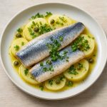 Plat de hareng salé dessalé servi avec pommes de terre vapeur, câpres et persil, recette bistrot traditionnelle.