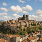 Vue panoramique réaliste de la cité haute de Saint-Flour avec la cathédrale et les maisons en pierre perchées sur le promontoire basaltique en Auvergne.