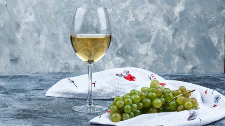 Chablis vin blanc posé avec une grappe de raisin.