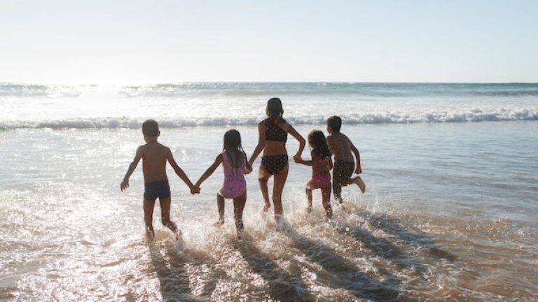 Séjour camping bord de mer avec enfants courant vers l'océan.